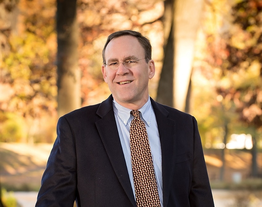 James M. Coleman seen posing for a photo in black color suit 